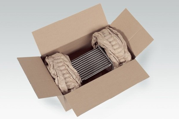Cardboard box with cushioning inner packaging Offener Karton mit Bauteil, das durch Papierpolster fixiert ist
